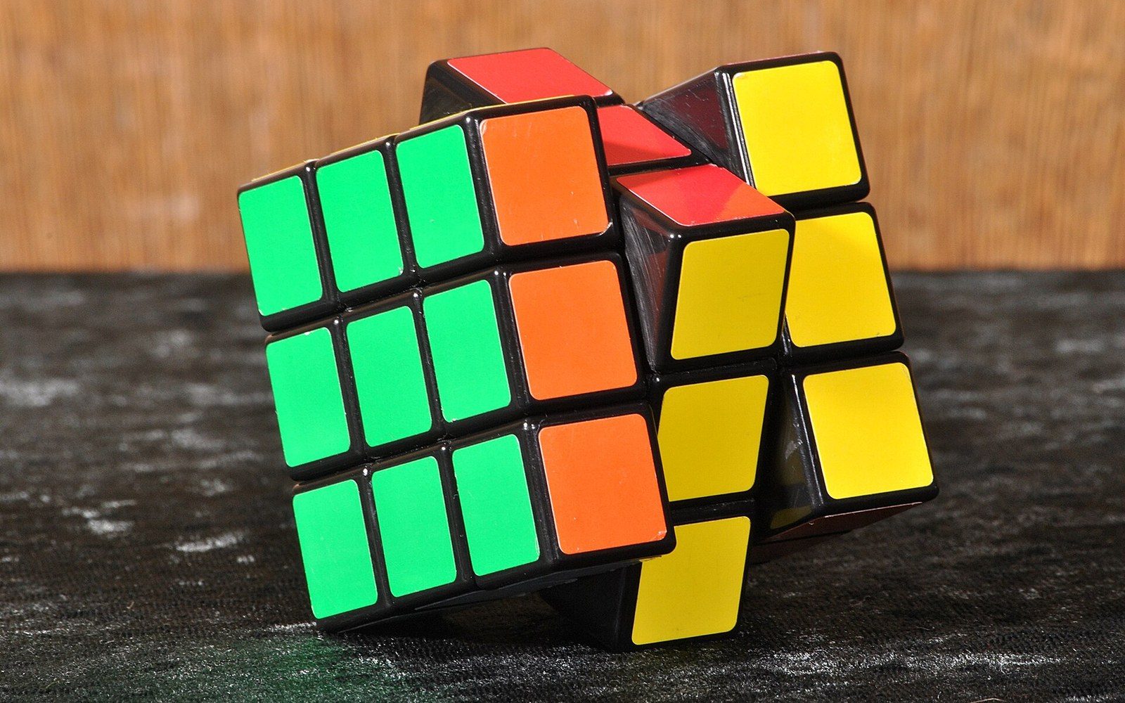 A rubik's cube twisted mid-rotation with its top layer angled off-axis